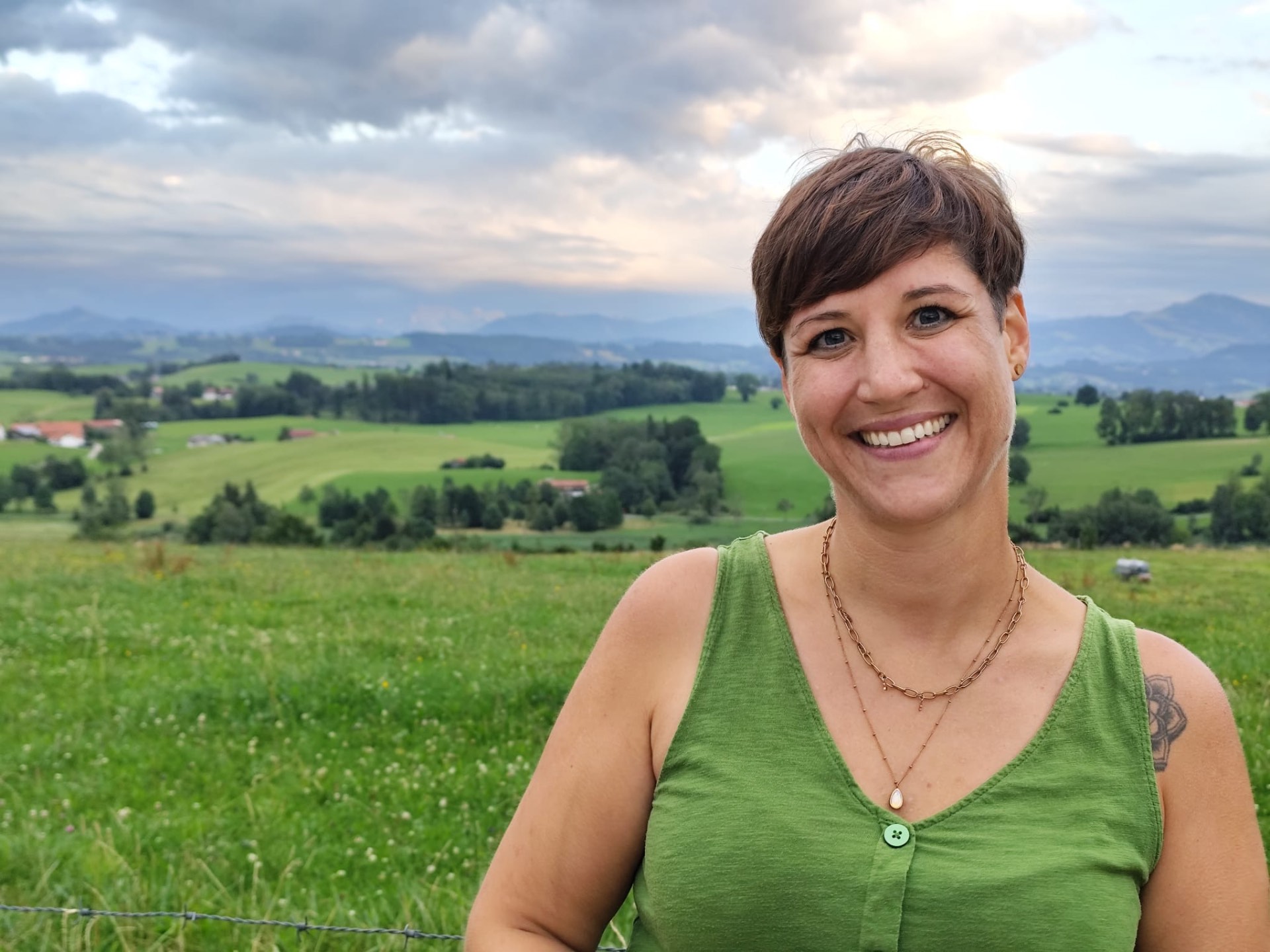 Steffi lächelt vor einer weiten Landschaft in die Kamera